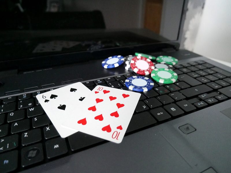 Laptop mit Spielkarten und Pokerchips